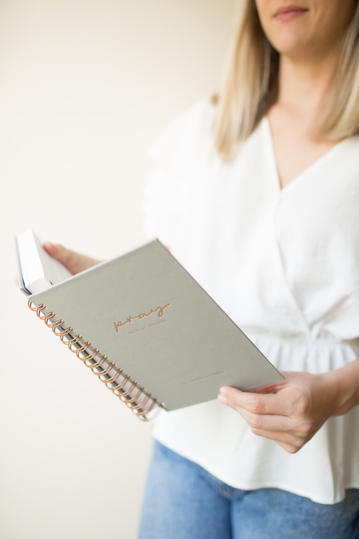 Plan your prayer time by using green prayer journal read by woman in white shirt